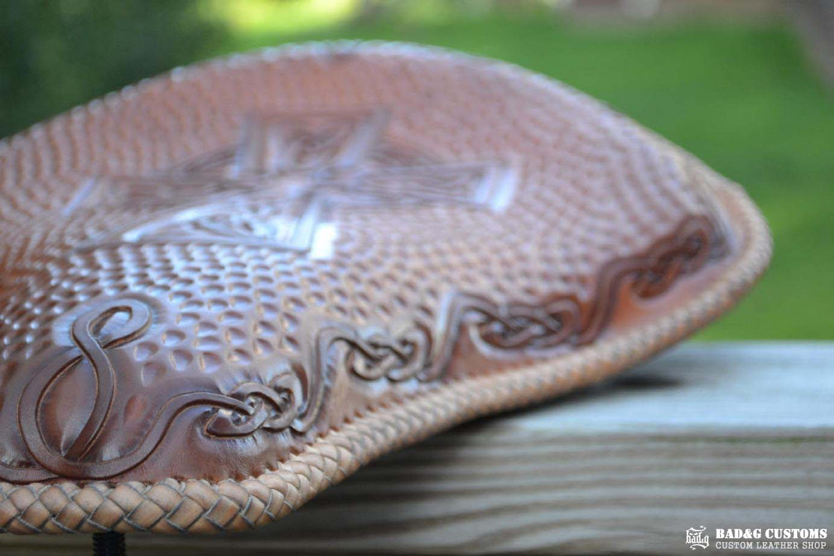 "CROSS" design hand tooled and braided on a chopper solo seat. Brown Veg tan leather with kangaroo lace.