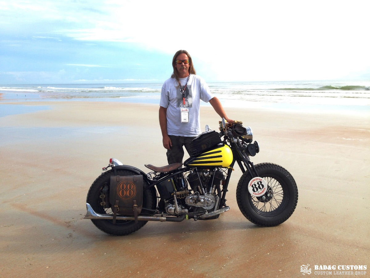 We’re proud to showcase a custom-made seat and saddlebags set crafted specifically for Doug Wothke, the legendary round-the-world motorcycle traveler. Made from hand-tooled and antiqued veg-tan leather, this set took countless hours of expert craftsmanship to complete. Designed for both durability and vintage authenticity, it will accompany him on the 2014 Cannonball Motorcycle Race, as he tackles this grueling challenge aboard his classic Harley-Davidson JD motorcycle. A true tribute to adventure!