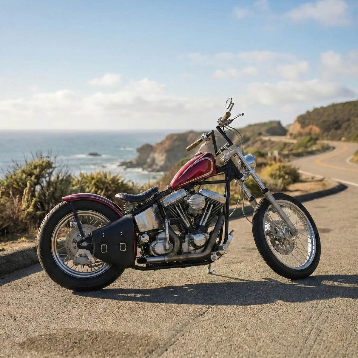 Motorcycle parked on a road with ocean and cliffs in the background